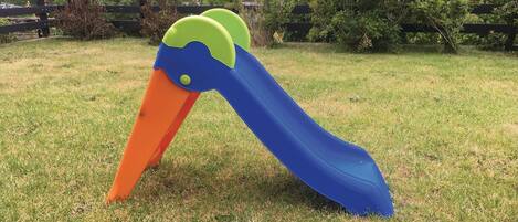 A playground slide with a large, colorful duck design.