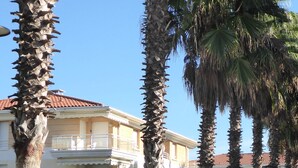 A building with a balcony and palm trees in the foreground. - Apartment near sea and city (Antibes)