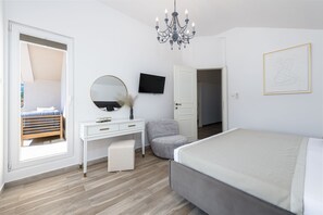 Une chambre à coucher moderne avec un lit, une commode, un miroir, un téléviseur et un lustre.
