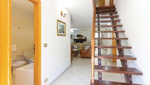 A staircase leading to a living area with a sofa, a fireplace, and a dining table. - Gorgeous home in Sassalbo -MS- (Sassalbo -MS-)