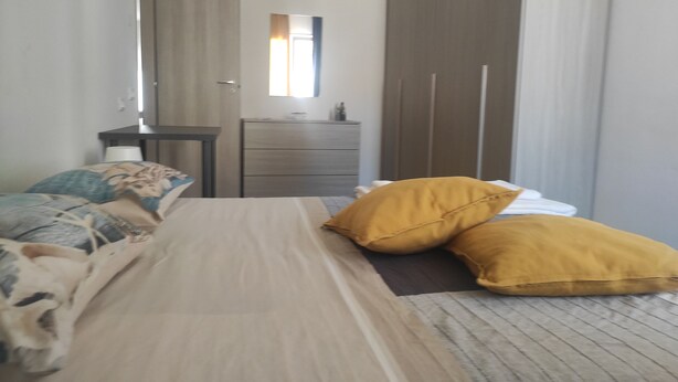 A bedroom with a bed, a dresser, and a mirror.