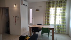 A dining area with a table, chairs, and a ceiling fan.