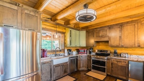 A modern kitchen with wooden cabinets, stainless steel appliances, and a granite countertop.