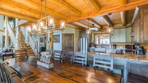 A spacious kitchen with wooden beams, a large island with seating, and modern appliances.