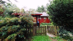 Ein rotes Haus mit Holzzaun und Briefkasten.