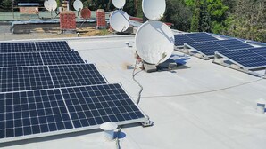 Una azotea con paneles solares y antenas parabólicas.