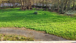 A grassy field with trees and a body of water in the background. - Bed and breakfast with hydromassage bath - St Thomas Castle (saint etienne de montluc)