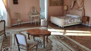 A bedroom with a bed, a chair, a desk, and a table. - Bed and breakfast with hydromassage bath - St Thomas Castle (saint etienne de montluc)