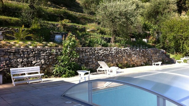 A pool area with stone walls, a bench, and lounge chairs. - houses / villas - 5 rooms - 6/8 persons (Magagnosc)