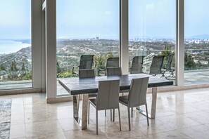 A conference room with a large table and chairs, large windows with a city view. - Pool & Coastline Views: Luxe La Jolla Home (La Jolla)