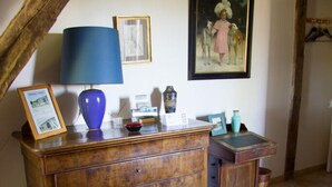 A rustic room with a wooden dresser, a blue lamp, a framed picture, and a painting on the wall. - Welcome to our house, we are happy to open its doors to you! (Calignac)