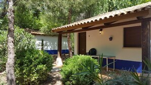 A covered outdoor area with a wooden bench, surrounded by greenery and trees. - Self catering Complejo Los Arenales for 4 people (Almagro)