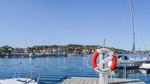 A marina with boats docked, a lifebuoy, and a wooden pier.