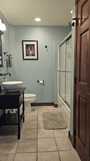 A bathroom with a sink, toilet, and shower.