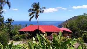 A tropical resort with red-roofed cabins overlooking the ocean. - ---- LOVE DESHAIES 2 --- (DESHAIES)