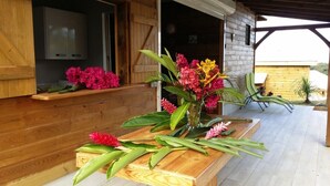 A wooden table with a vase of flowers, a wooden bench, and a TV on a wall. - ---- LOVE DESHAIES 2 --- (DESHAIES)