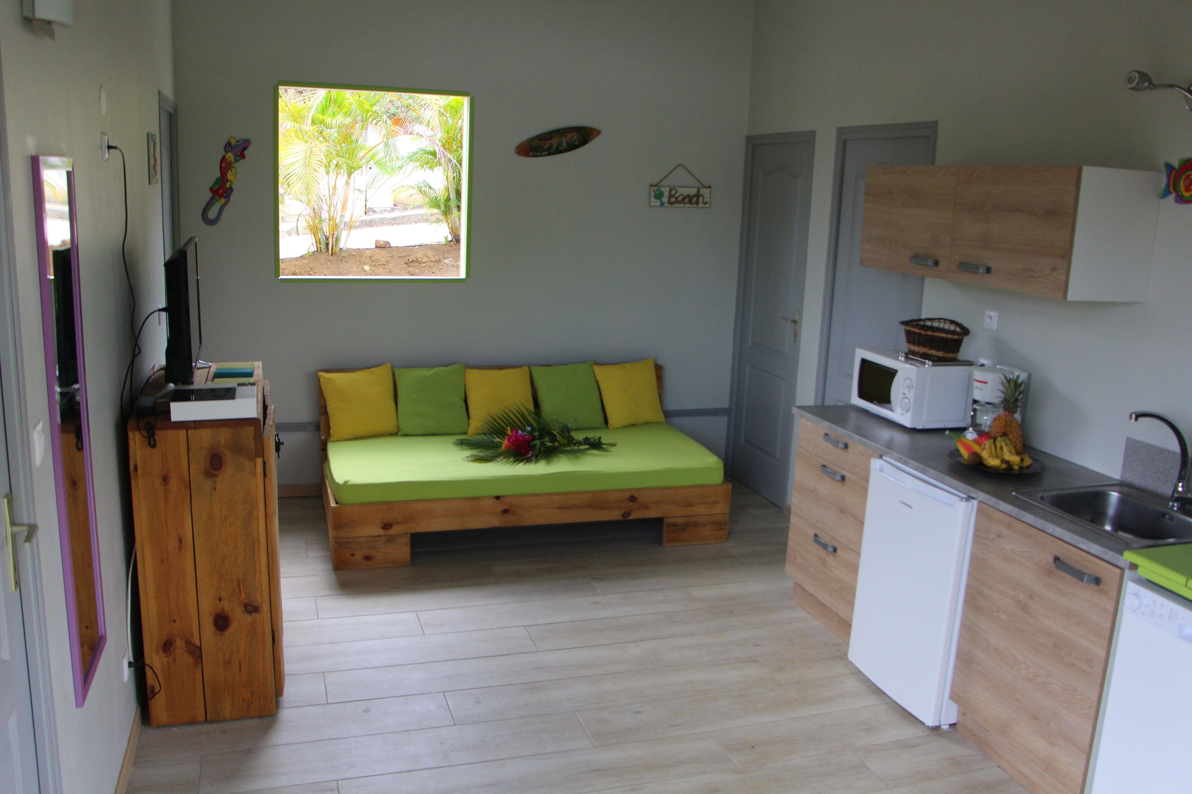 A compact kitchen with a wooden bench and a microwave.
