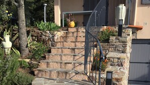 A stone staircase leading to a house with a metal railing, surrounded by greenery and potted plants. - Beautifull villa, 3,360 sq.m garden; only 1 km away from the Saint-Endréol golf club (La Motte)