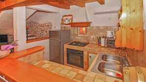 Une cuisine compacte équipée d’un réfrigérateur, d’une cuisinière, d’un four et d ’un évier à deux bacs.
