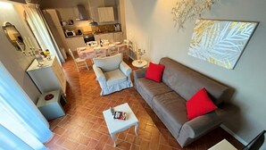 A living area with a sofa, a coffee table, and a dining table set for four.