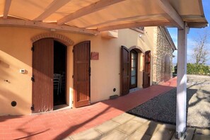 Un bâtiment doté d’un porche, d’un chemin en briques et d’un mur en pierre.