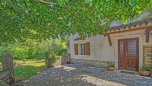 A stone-paved courtyard with a rustic building featuring a wooden door and shuttered windows. - Holiday house Filip * large plot with garden, private pool, free WiFi (Nedescina)