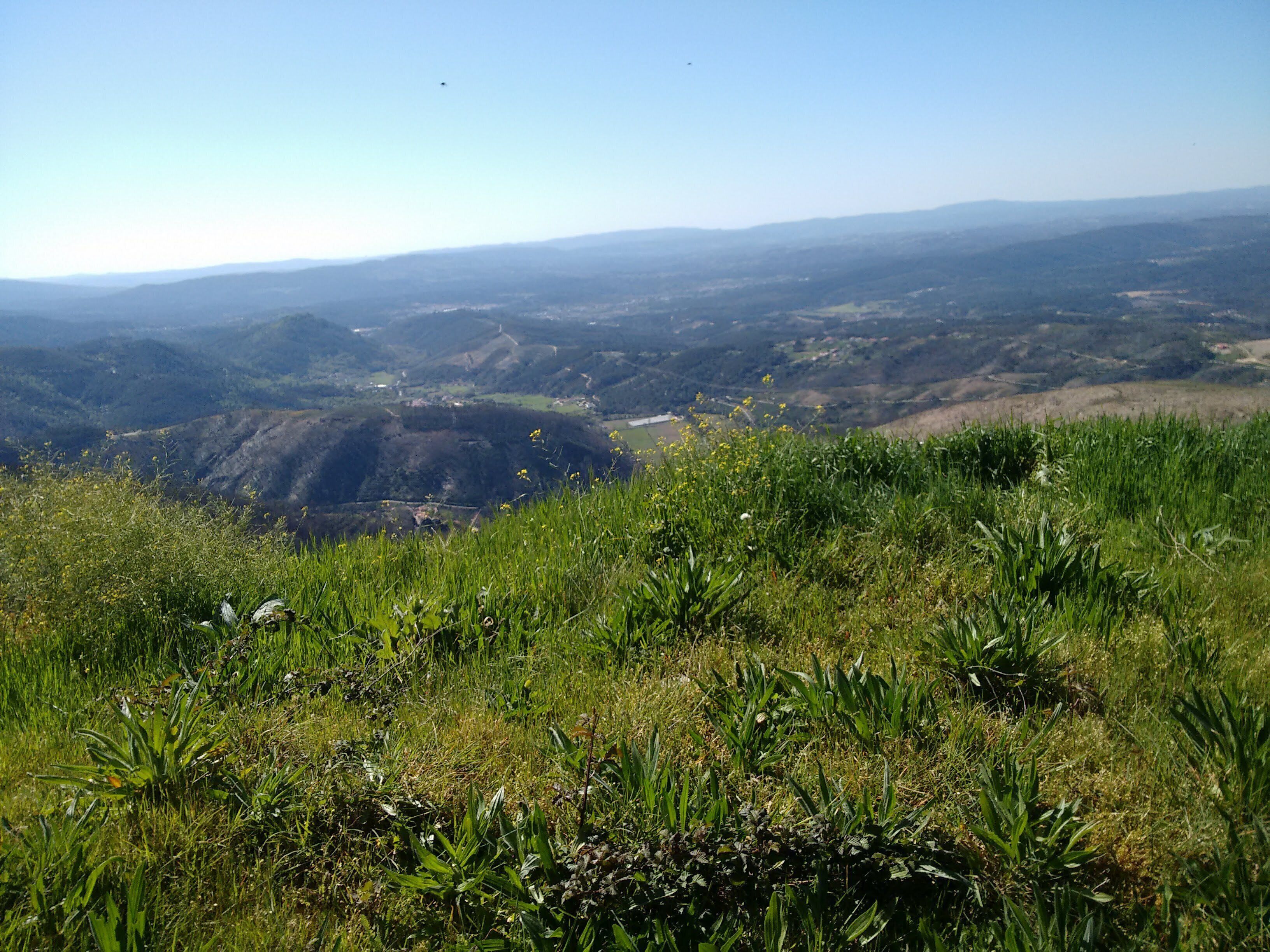 A panoramic view of a mountainous landscape with a clear sky.