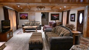 Una sala de estar acogedora con chimenea, sofás de cuero y televisor.