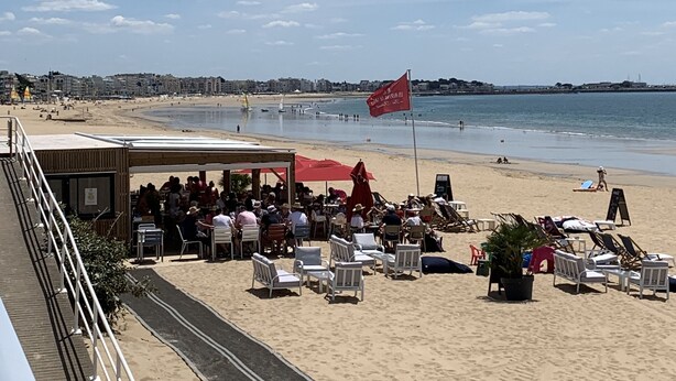 Un restaurante frente a la playa con terraza al aire libre y vistas a la orilla.
