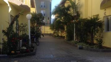 Stroll through this charming courtyard, surrounded by buildings with balconies and lush greenery.
