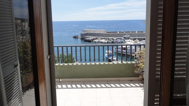 Un balcón con vista a un puerto deportivo y al mar.