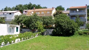 A residential area with houses, a stone wall, and a grassy field. - Apartment in Lopar with Terrace, Air condition, WIFI, Washing machine (129-2) (Lopar)