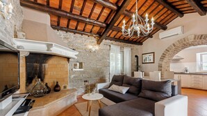 Ein gemütliches Wohnzimmer mit Kamin, einer Kristallleuchter und einem modernen Sofa.