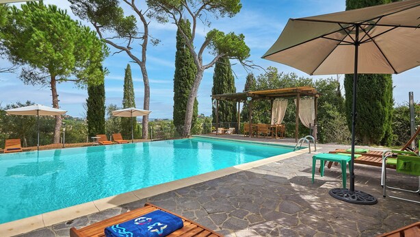A swimming pool with lounge chairs and umbrellas, surrounded by trees and a pergola. - Apartment on the first floor with a beautiful panoramic view, Air conditioning. (Torrita di Siena)