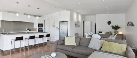 A modern living space with a kitchen, dining area, and seating area.