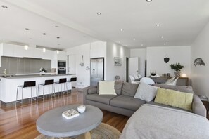 Un espace de vie moderne comprenant une cuisine, un coin repas et un espace détente.