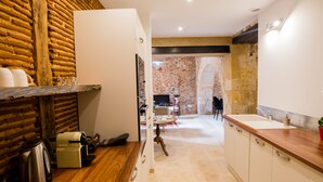 A kitchen with a wooden countertop, a sink, and a brick wall. - Charming apartment in the heart of bergerac (Bergerac)