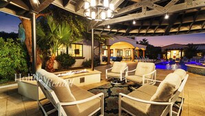 An outdoor patio area with lounge chairs, a fire pit, and a pool. - Entertainer's Paradise - 8BR PV Estate w/ Splash Pad & Pickleball (Paradise Valley)