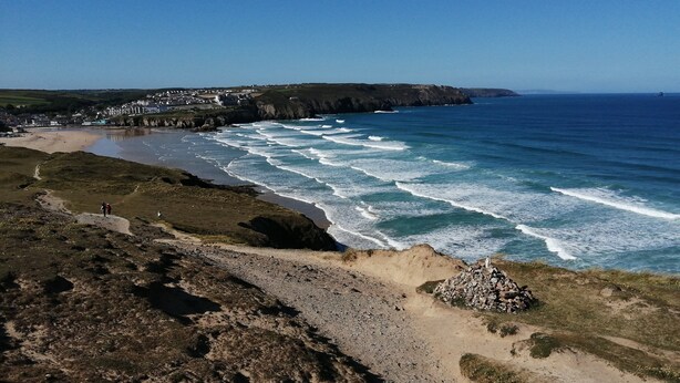 A coastal landscape with a beach, rocky terrain, and a distant village. - Romantic Cottage, Perranporth, Sleeps 2, Dog friendly, Walking distance to Beach (Perranporth)