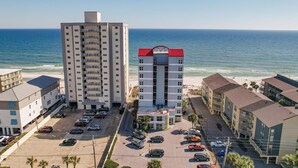 Un hôtel situé sur la côte, composé de plusieurs bâtiments, doté d’un parking et offrant une vue sur l’océan.