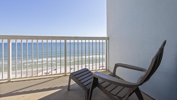 Un balcon avec vue sur la plage et l’océan.