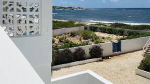 Vista sulla costa con un edificio bianco, una spiaggia sabbiosa e l'oceano.