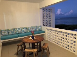 Relax on the balcony with a round table and comfortable seating, taking in the ocean view.