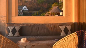 A cozy seating area with a view of a hillside with buildings and trees. - 5 Star Luxe, Ocean Views, Walk to Beach & Village, Full Staff, 8-10 BR Rates (Sayulita)
