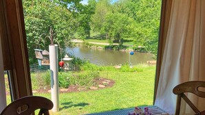A dining table with a view of a pond and trees.