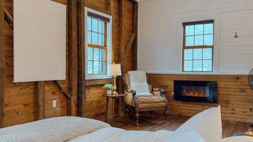 A cozy room with a fireplace, a large window, and a comfortable chair.