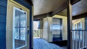 L’entrée d’un hôtel, avec un portail en métal, une porte dotée d’une fenêtre et un ascenseur.