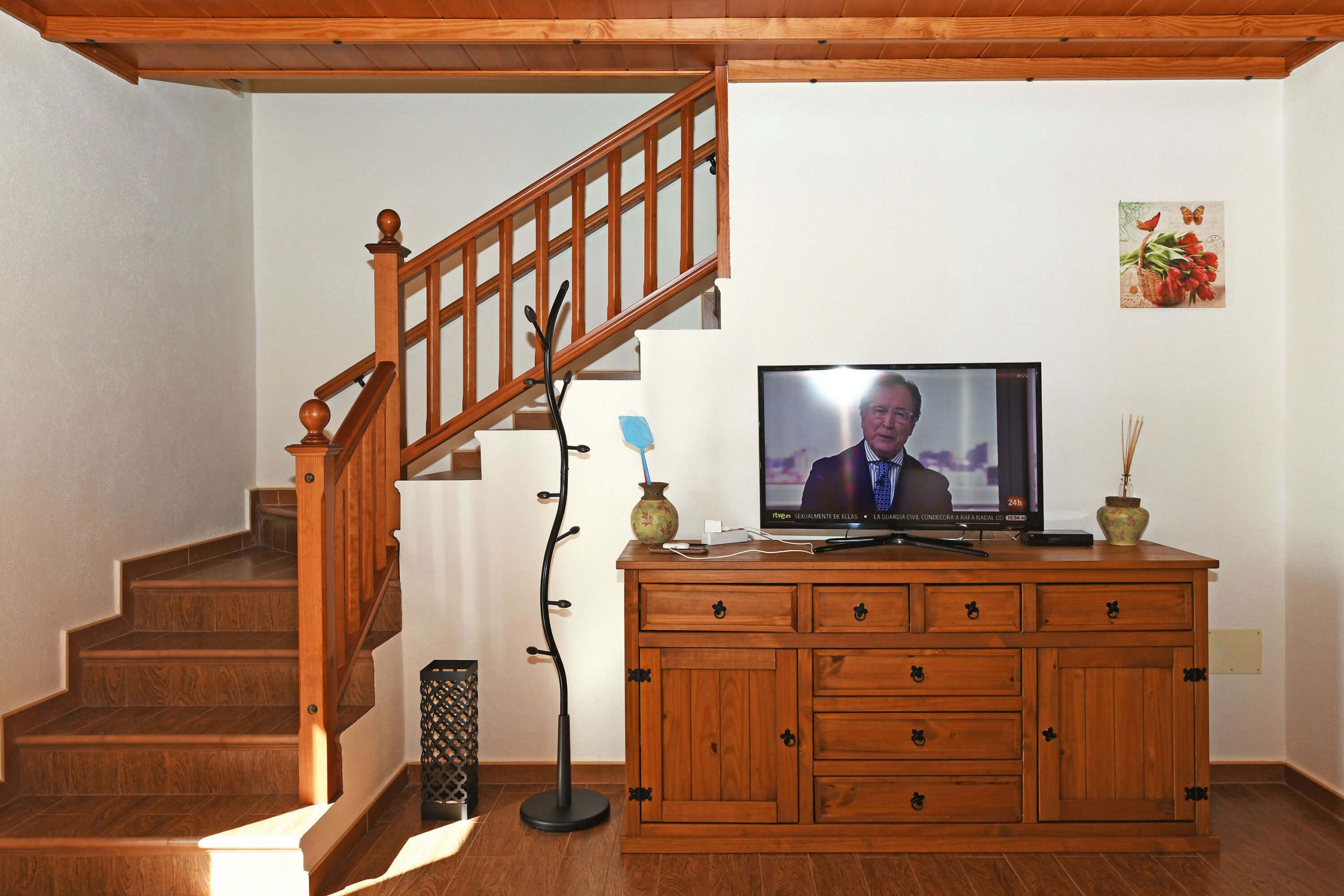 En trätrappa med en tv placerad ovanpå ett träskåp.