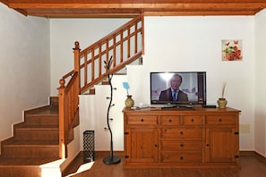A wooden staircase with a TV on a wooden cabinet.