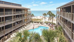 A hotel with a pool area, multiple balconies, and a view of the beach. - Sandpiper 1A ~ Family Fun ~ Comfortable ~ Corner Unit (Gulf Shores)